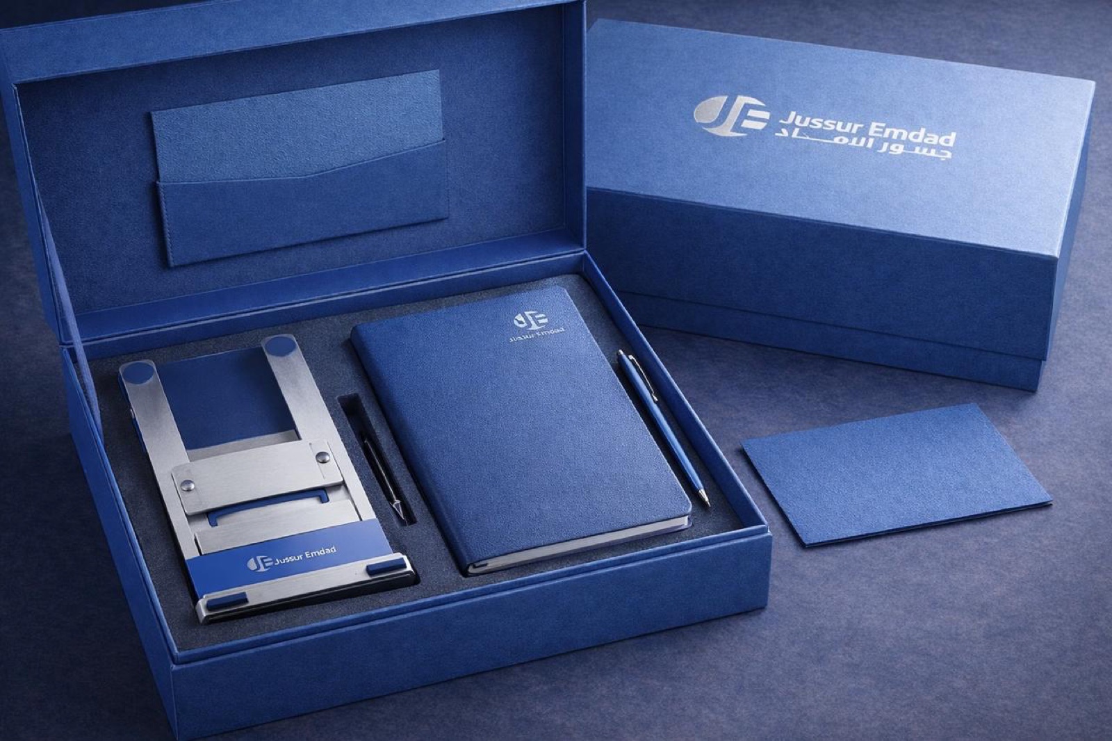 بوكس هدايا تنفيذي بلون أزرق يضم دفتراً وقلماً وحامل بطاقات معدني مع حفر الشعار من تنفيذ أساس وير